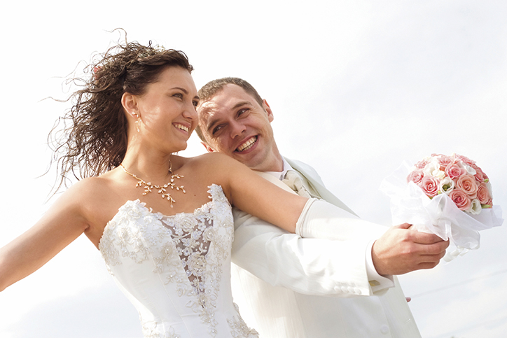 bride and groom in white with flowers