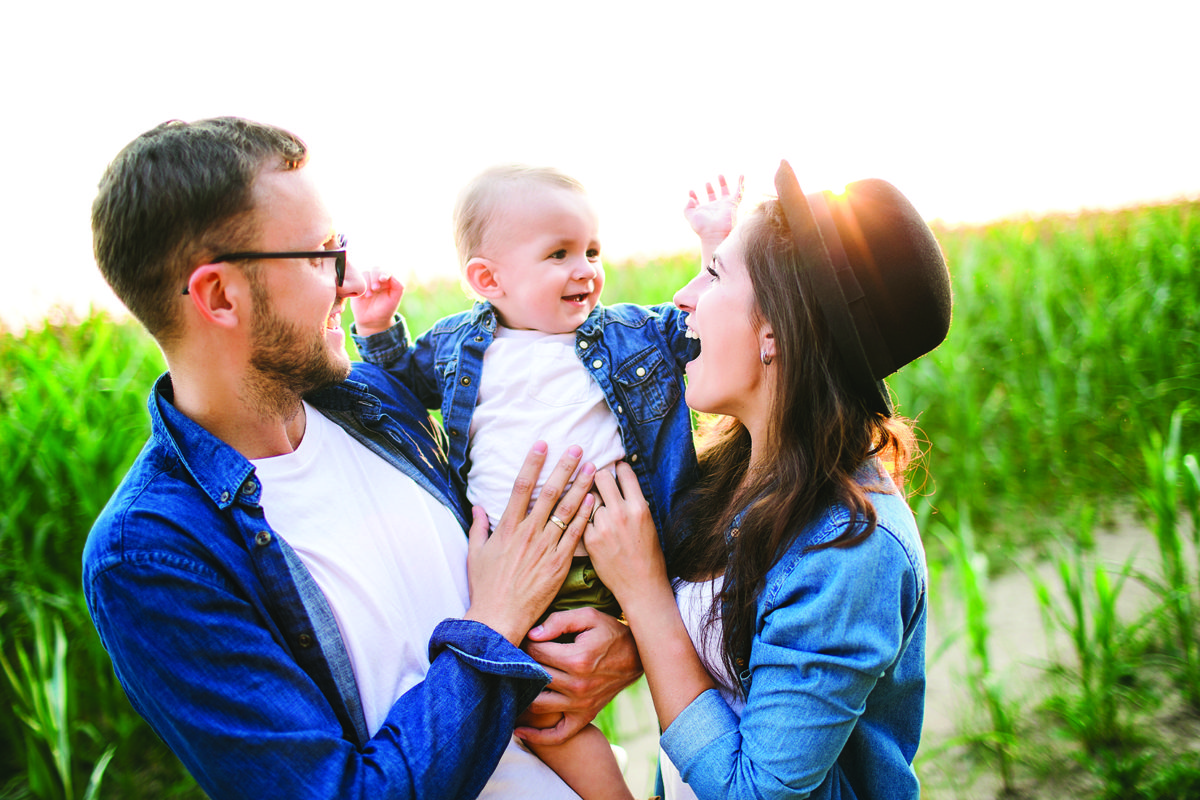 mom and dad holding baby and smiling