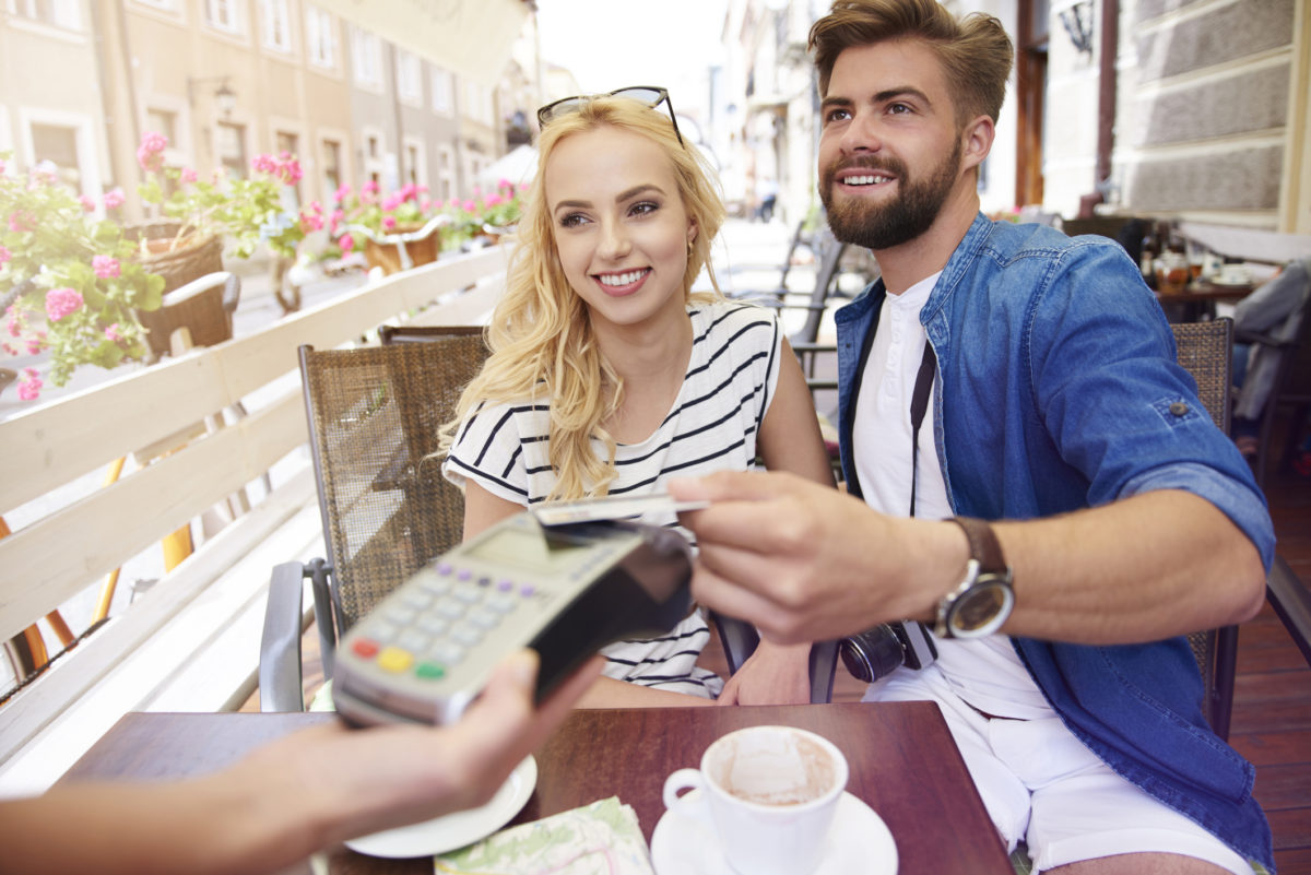 couple at an outside table paying for food