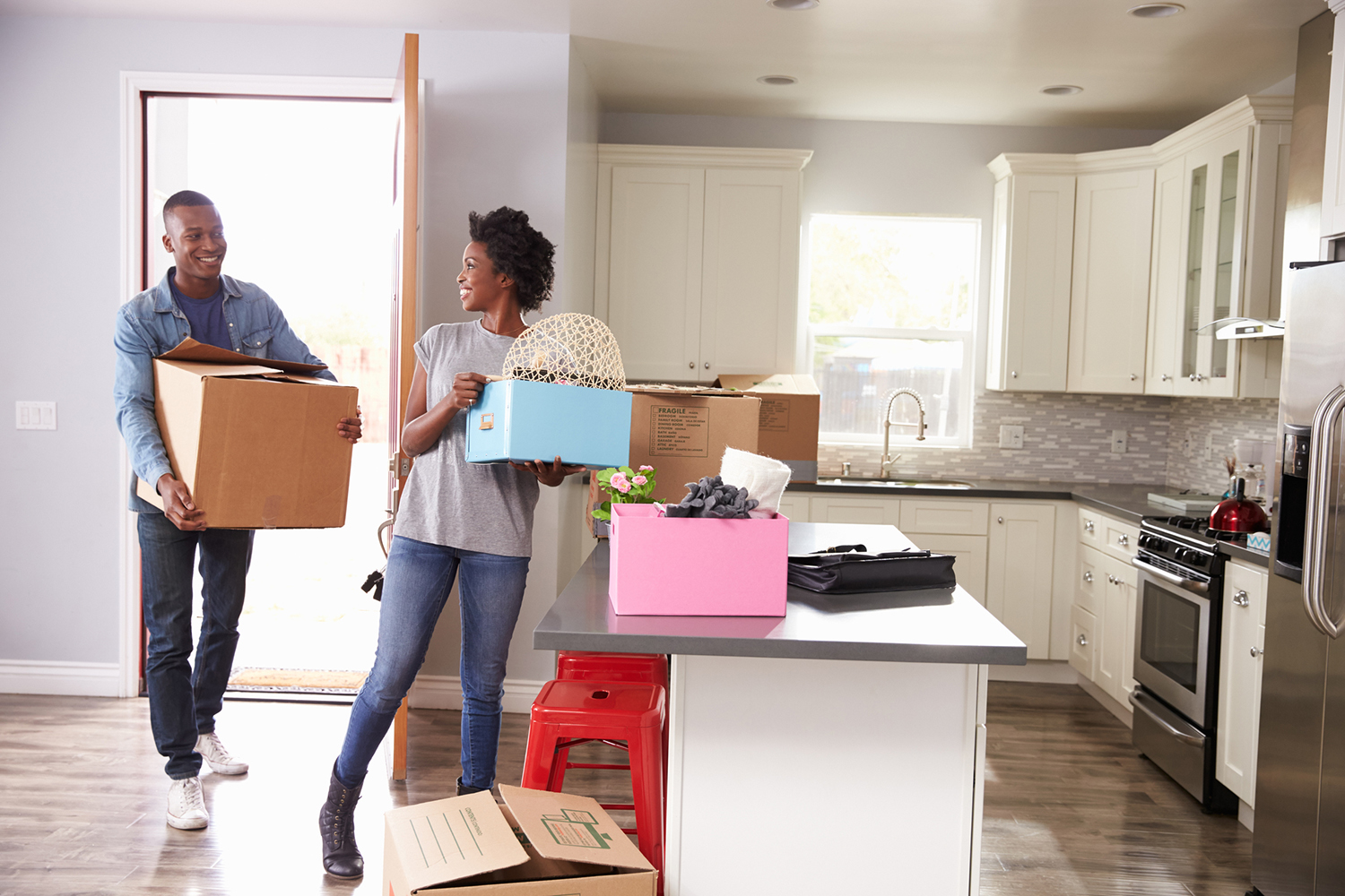 couple moving boxes into new home kitchen