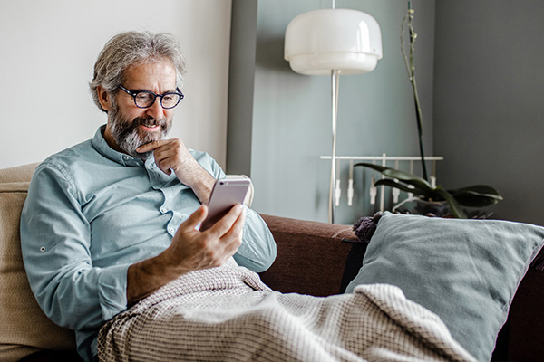 A man is in her modern apartment using a mobile phone