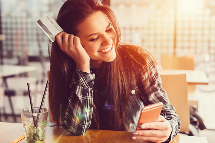 girl with credit card using phone