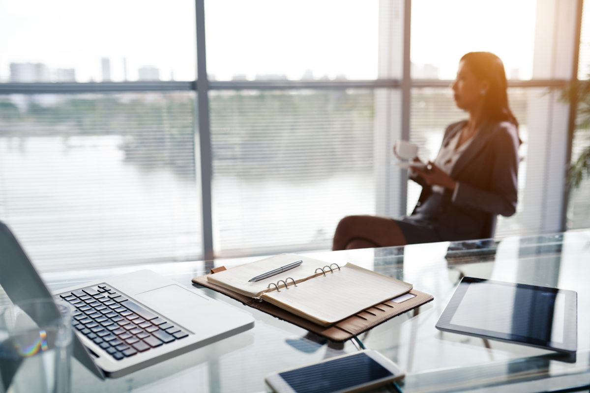 business woman looking out the window next to her desk