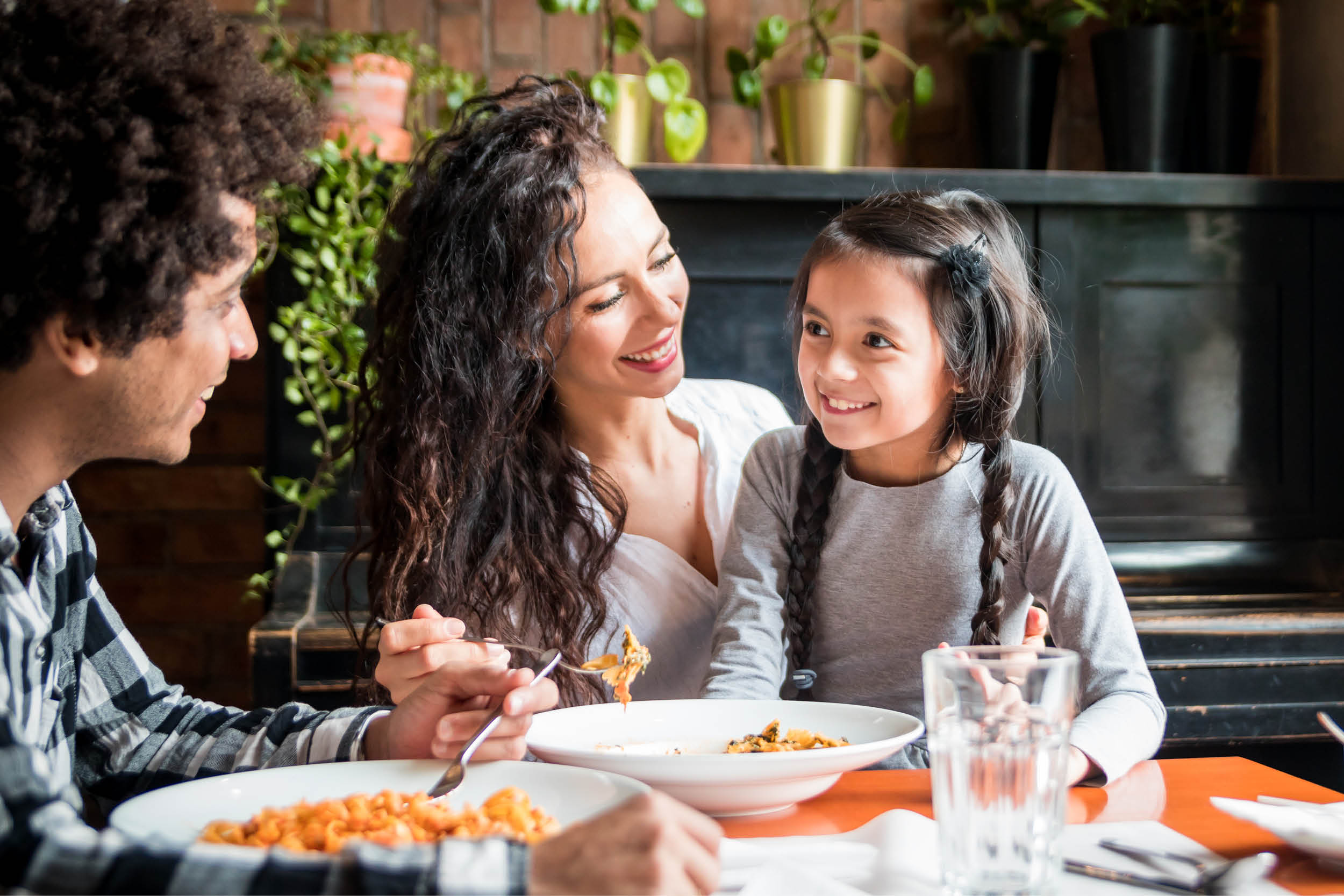 man and women with little girl eating